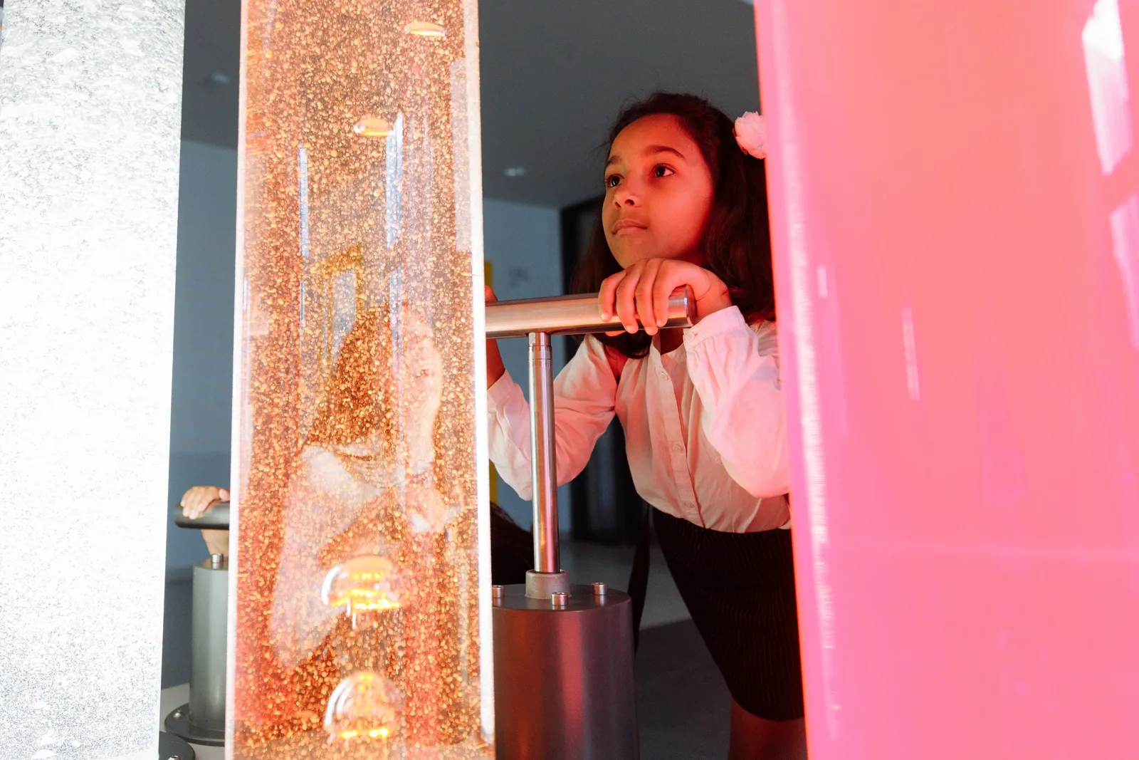 Une jeune fille s’émerveille devant une expérience dans un musée des sciences