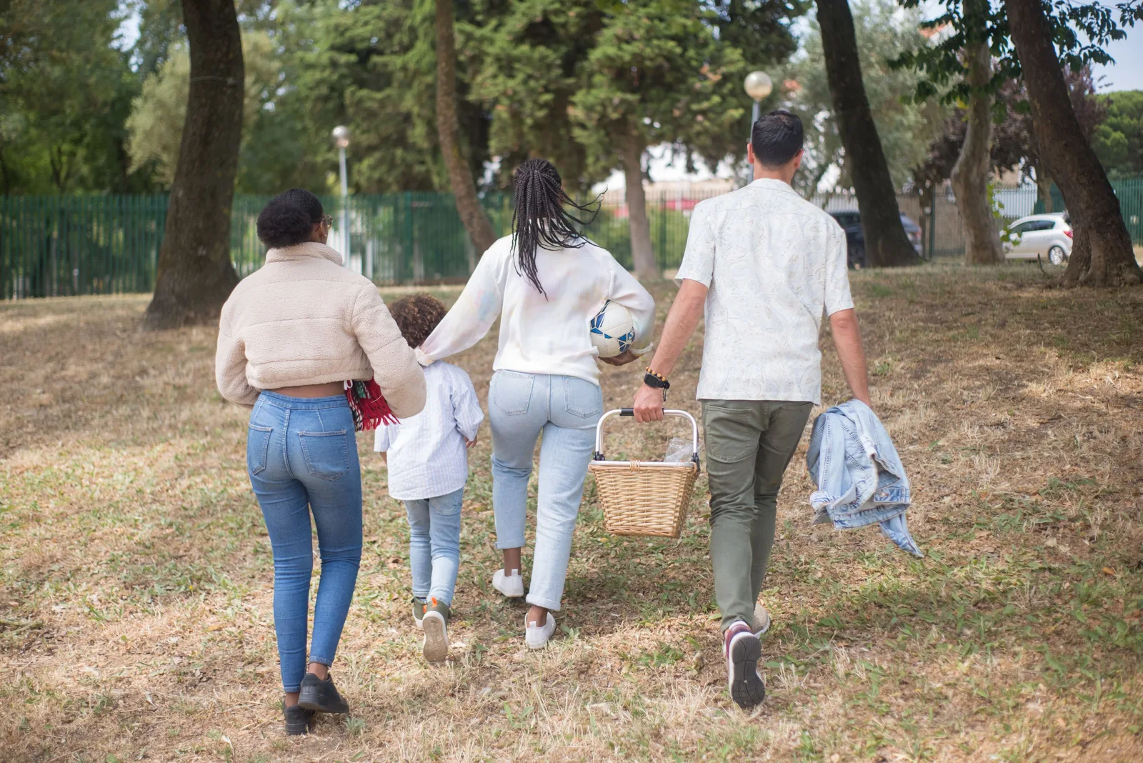 Une famille traverse un pré avec un panier de pique-nique